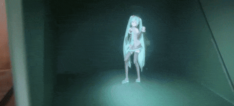 GIF of Hatsune Miku projected as a hologram in a small box.